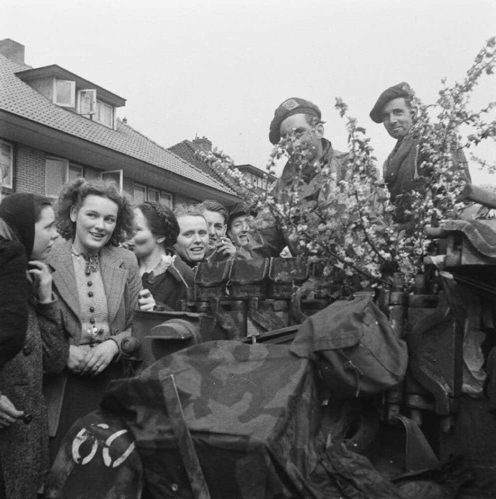 Des femmes accueillent les soldats britanniques avec des fleurs c Anefo