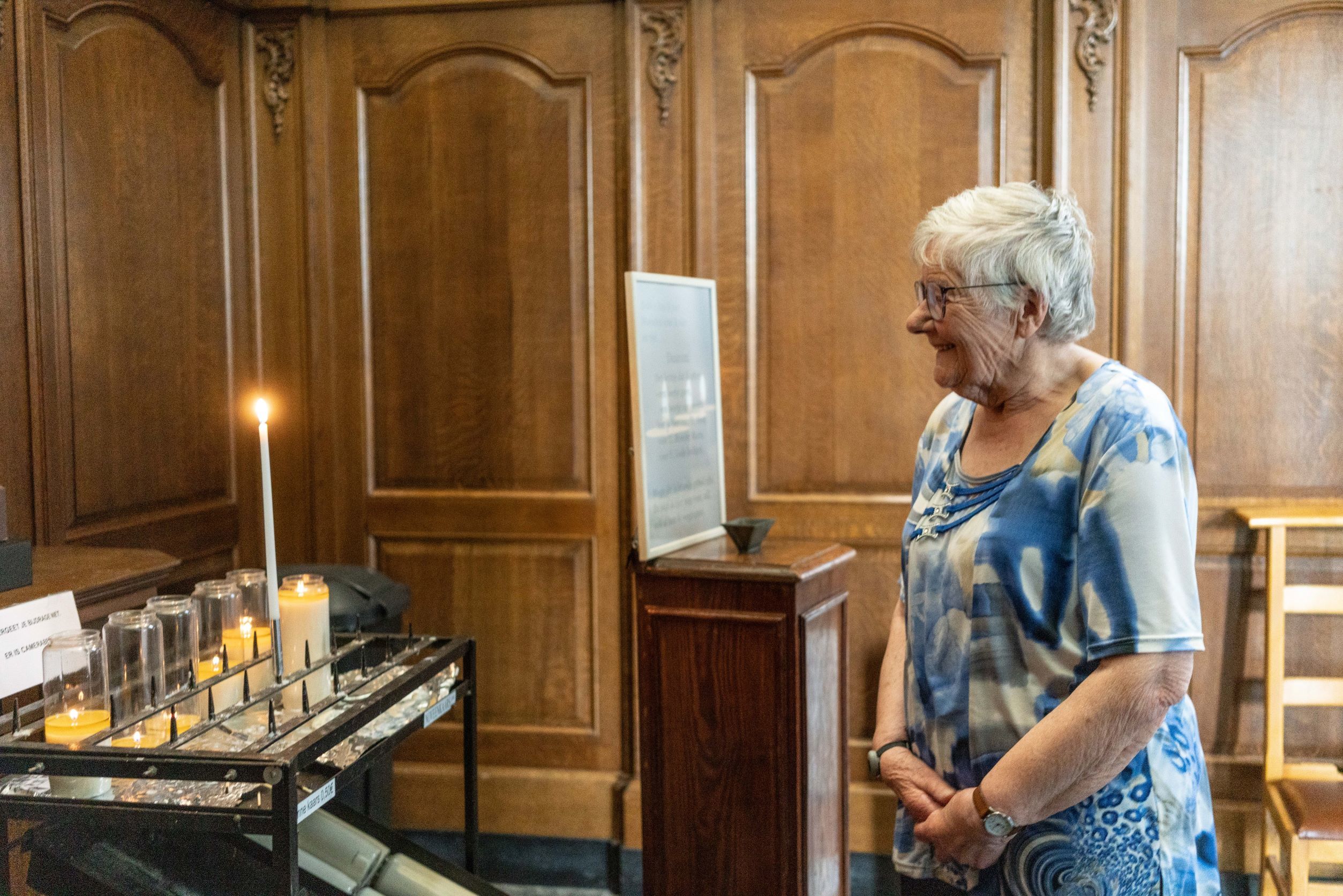 Odette contemple un cierge dans léglise Saint Antoine d Okegem