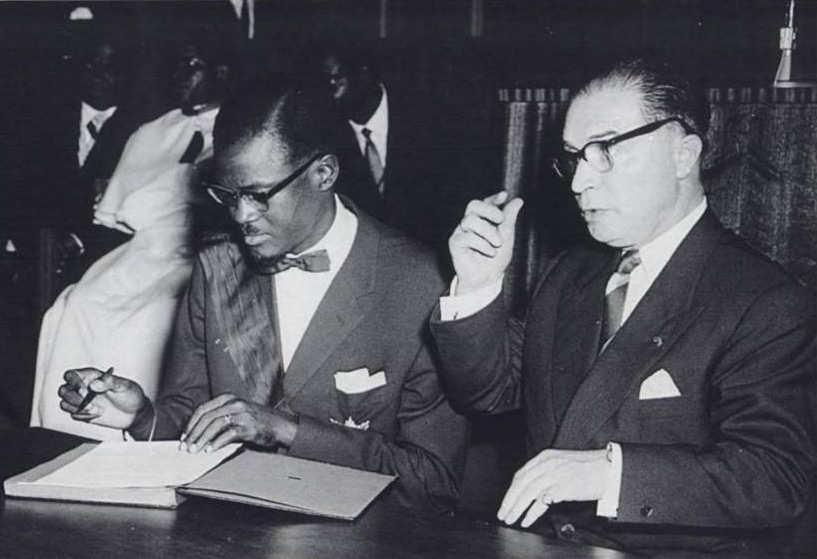 Patrice Lumumba signs the document granting